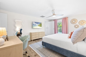 A modern bedroom with a bed, a desk, a chair, a dresser, and a ceiling fan. - Family Resort Near Beaches, with Heated Pool, Hot Tub, Mini Golf & Games (Bradenton)