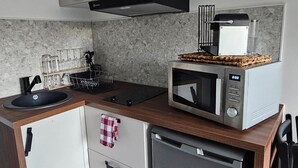 A compact kitchen with a microwave, toaster, and dishwasher.