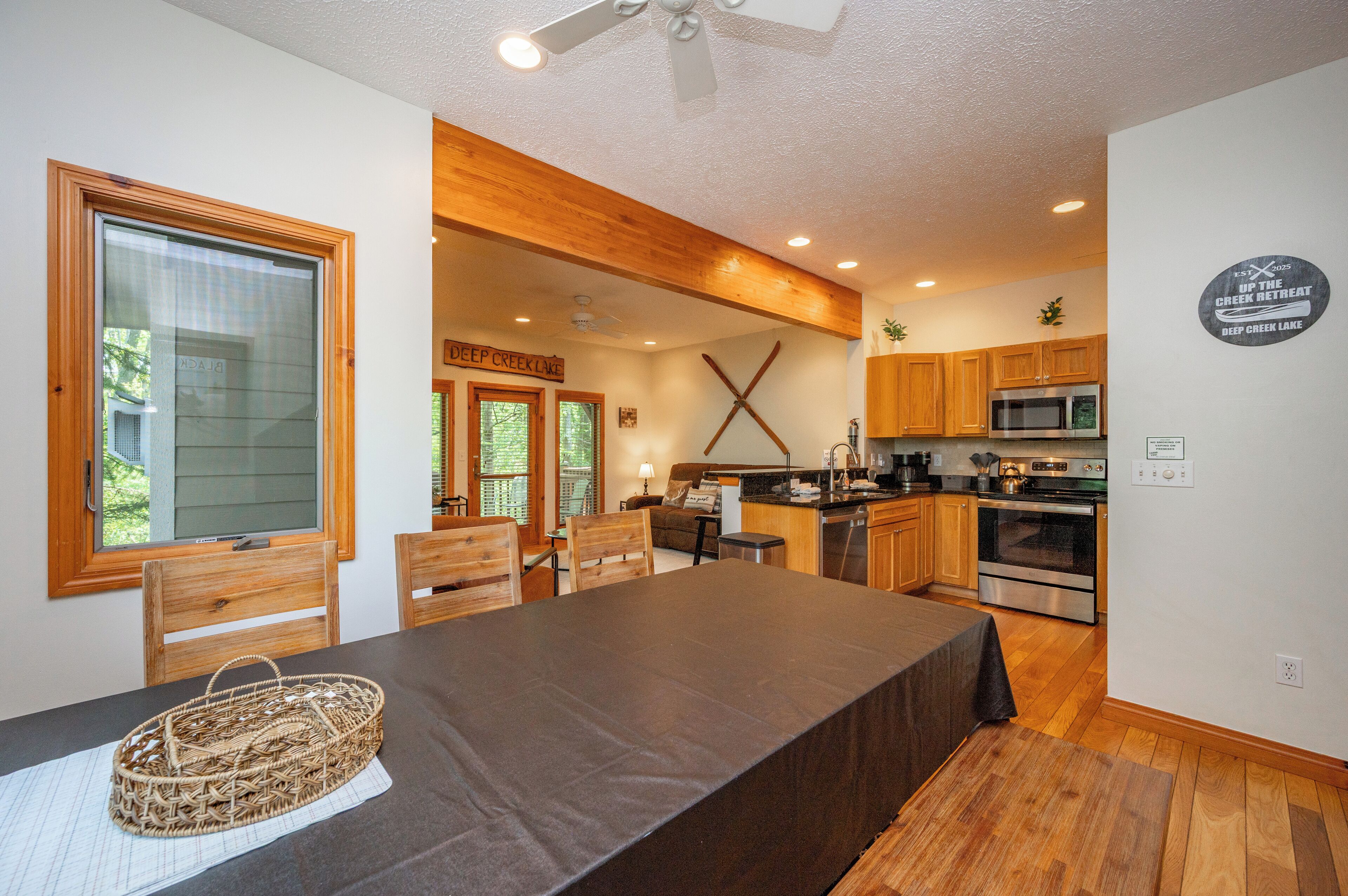 A modern kitchen with wooden cabinets, a large island, and a dining area with a table and chairs.
