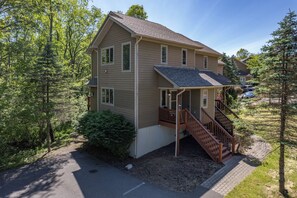 A two-story house with a covered porch and a staircase leading to the second floor.