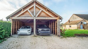A wooden garage with two cars parked inside. - The Vagastines (Saint-Germain-du-Plain)