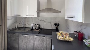 A modern kitchen with marble backsplash, stainless steel appliances, and a sleek countertop. - [ Martiry Suite Apartment ] + Self Check-in Late (Catania)