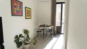 A modern apartment with a dining area, a potted plant, and artwork on the walls. - [ Martiry Suite Apartment ] + Self Check-in Late (Catania)