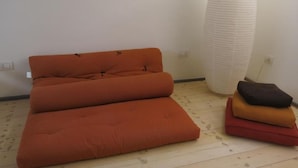 A room with a sofa and a tall, textured vase. - Puccini- un bel dì (Cagliari)
