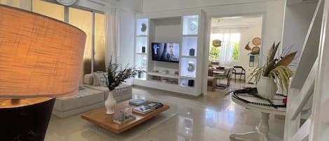 A spacious living room with a television, a coffee table, and a sofa.