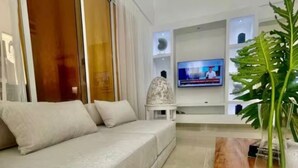 Een moderne woonkamer met een bank, een salontafel en een televisie.