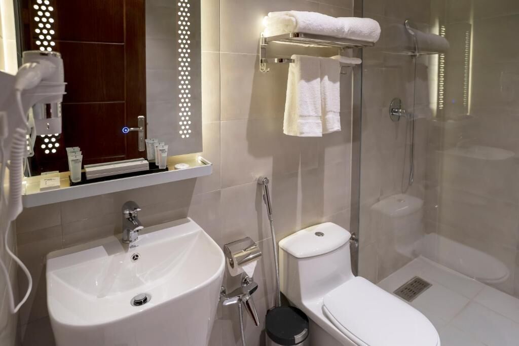 A modern bathroom with a sink, toilet, and glass-enclosed shower.