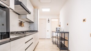 A modern kitchen with a gas stove, stainless steel cabinets, and a black countertop.