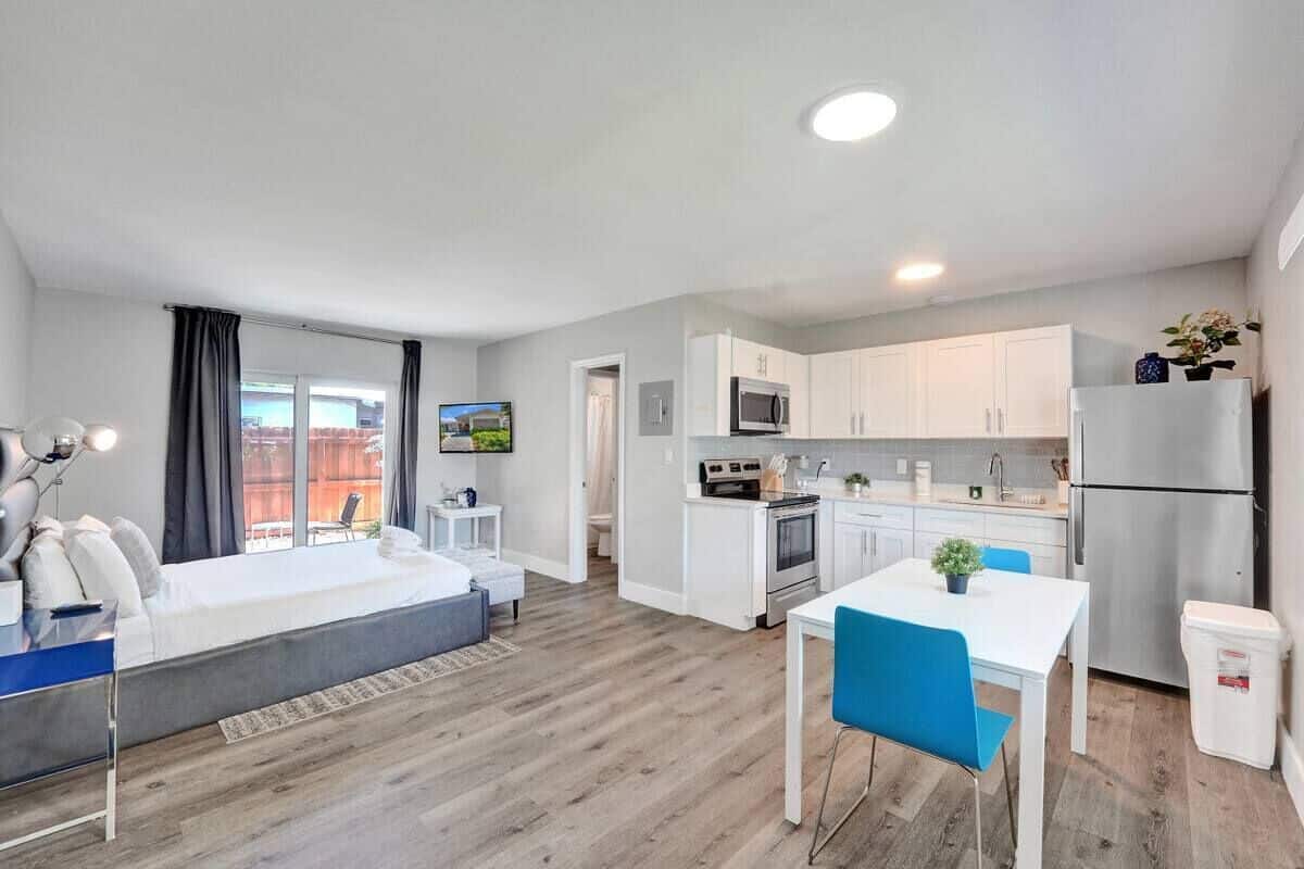 Un appartamento moderno con zona living, angolo cottura e un piccolo spazio pranzo.