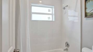 A bathroom with a bathtub, a shower, and a toilet.