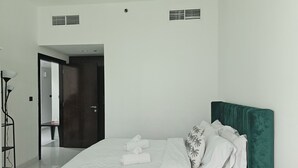 Et hotelværelse med en seng, et natbord, et spejl og en dør til et badeværelse.