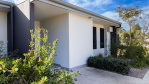 A modern house with a flat roof, large windows, and a covered porch. - Modern Queen Studio - 6 Min Walk to Callala Beach (Callala Beach)