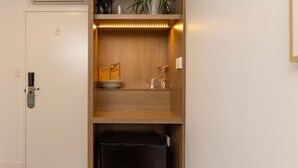 A compact kitchenette with a wooden cabinet, a coffee maker, and a trash bin. - Modern Queen Studio - 6 Min Walk to Callala Beach (Callala Beach)