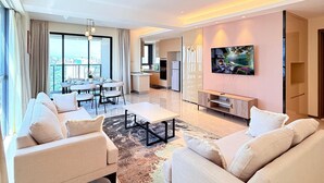 Una sala de estar moderna con un sofá, una mesa de centro y un televisor montado en la pared.