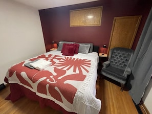 Un dormitorio con cama, una silla, una mesita de noche y un armario.