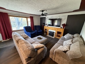 Una sala de estar con un conjunto de sofás, una mesa de centro y una chimenea.