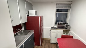 A compact kitchen with a microwave, refrigerator, and oven.