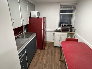 A compact kitchen with a microwave, refrigerator, and oven.