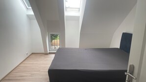 Un dormitorio con una cama grande, ventanas de tragaluces y vistas al exterior.