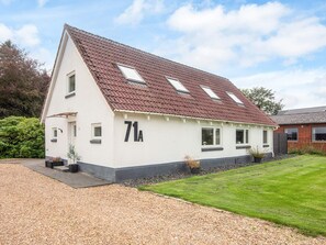 A single-story house with a sloped roof, a number '71A' on the side, and a gravel driveway. - 4 Star Holiday Home in Henne (Henne)