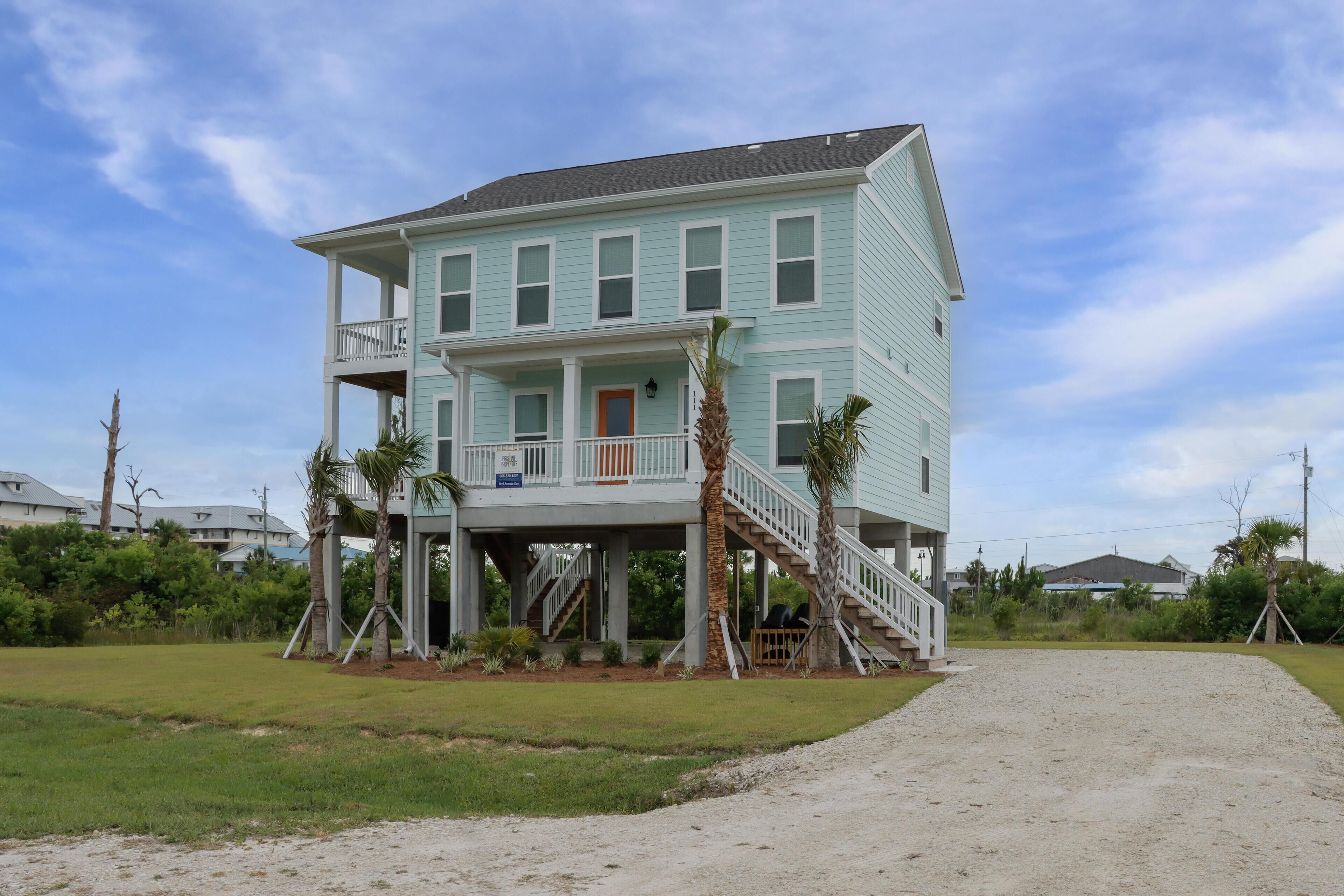 A two-story house with a balcony, a front porch, and a staircase leading to the second floor.