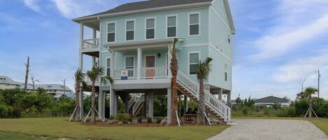 A two-story house with a balcony, a front porch, and a staircase leading to the second floor.