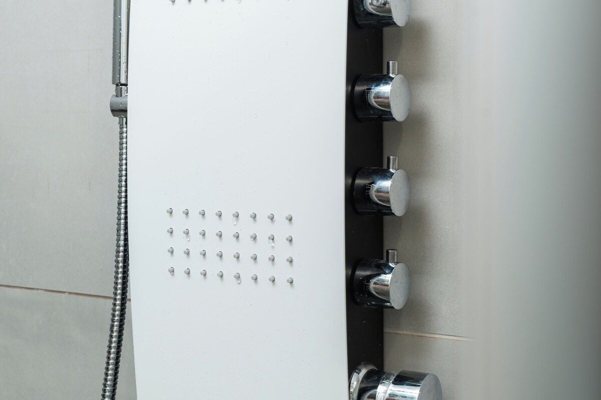 A modern shower with multiple spray heads and a handheld showerhead.
