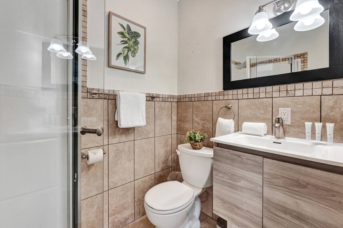 Un bagno moderno con WC, lavabo e zona doccia.
