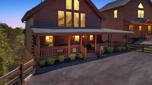 A large wooden lodge with a porch and multiple windows. - Rustic Retreat – Jacuzzi, Fireplaces & Views (Sevierville)