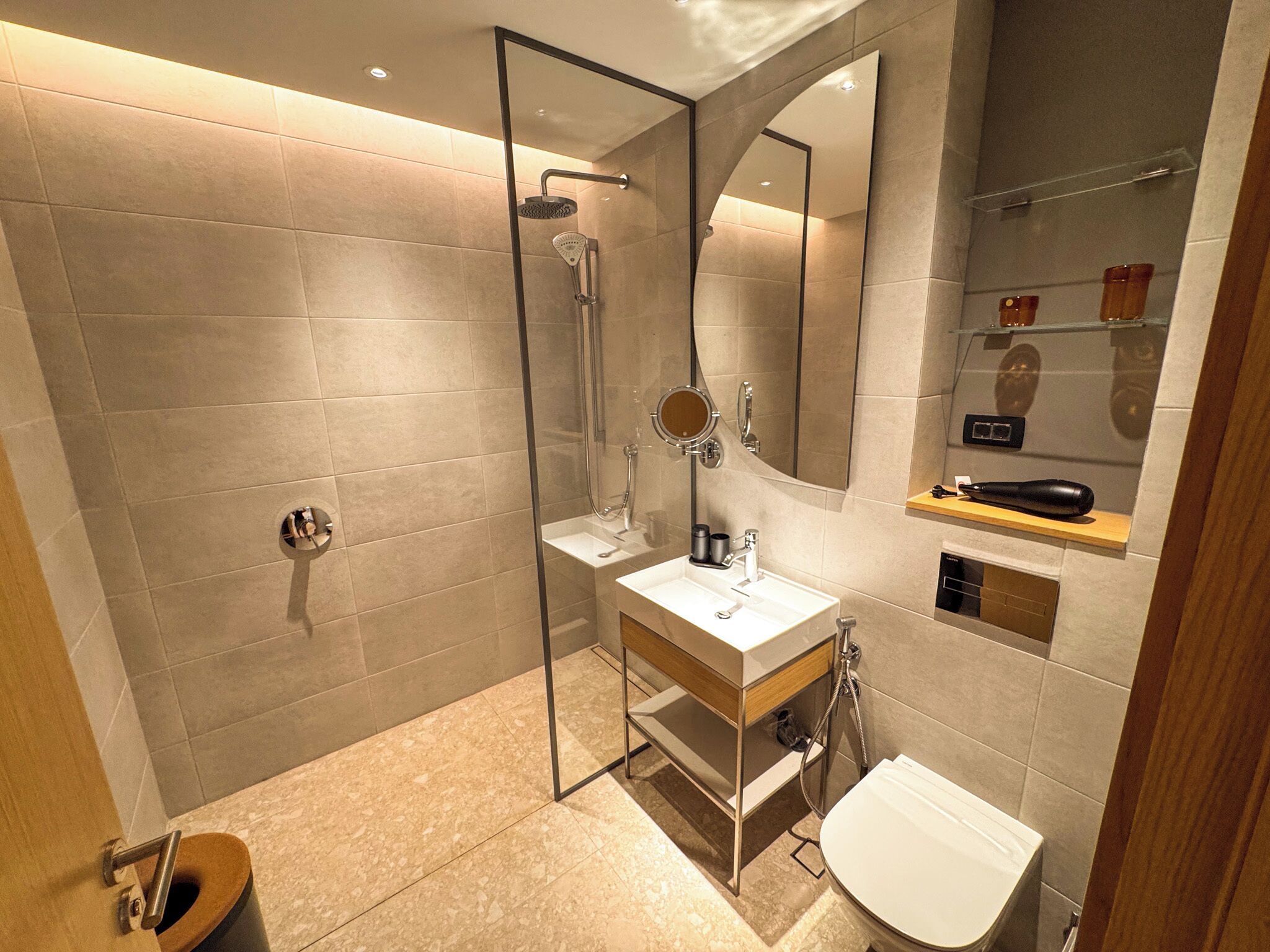 A modern bathroom with a glass-enclosed shower, a vanity with a mirror, and a toilet.