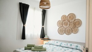 Ein Schlafzimmer mit Bett, Nachttisch, Lampe und Wandbild.