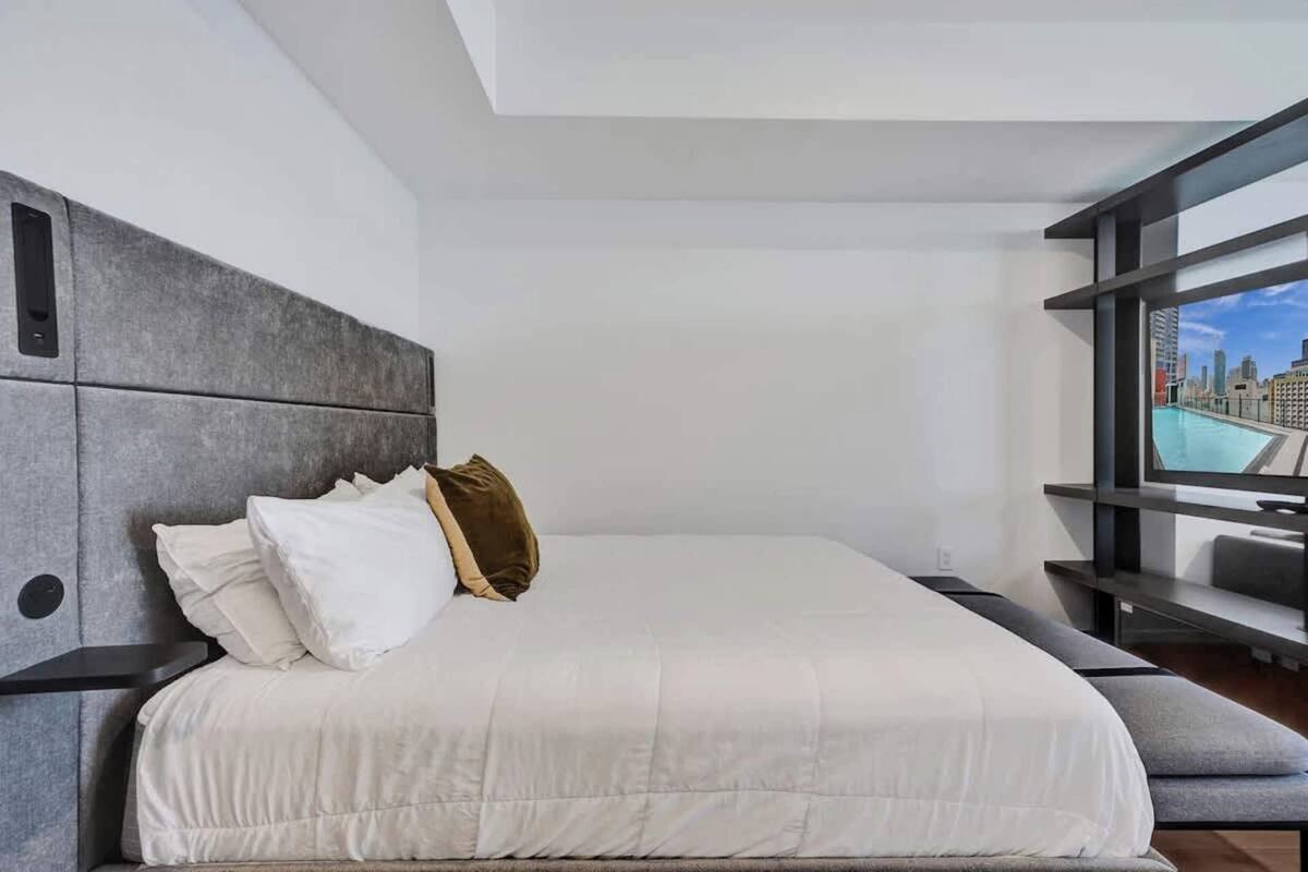 Una habitación de hotel moderna con una cama grande, vistas a la ciudad y un diseño minimalista.