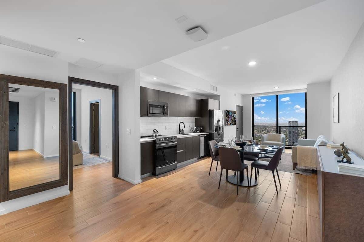 Un apartamento moderno con cocina, comedor y vistas a la ciudad.