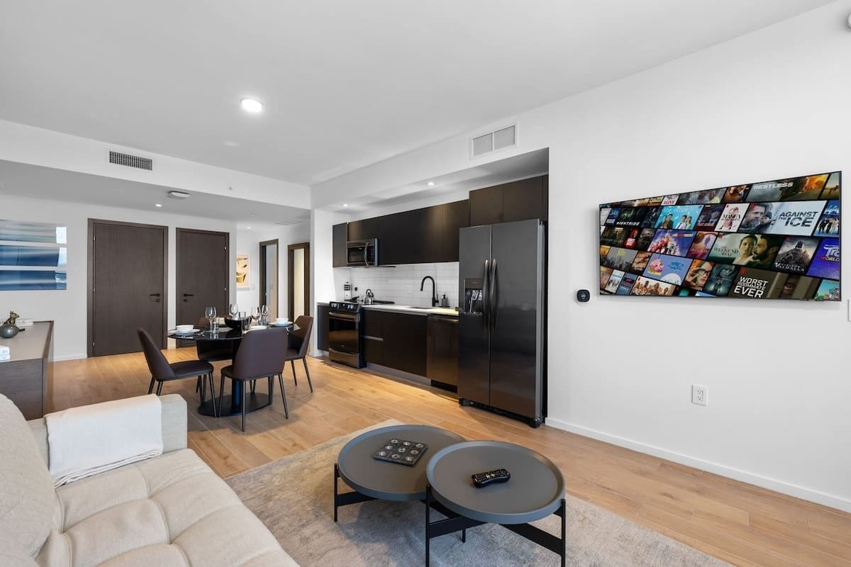 A modern apartment with a living room, dining area, and kitchen.