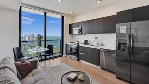 Una cocina moderna con vistas, un área de comedor con mesa y sillas, y una sala de estar con sofá y mesa de centro.