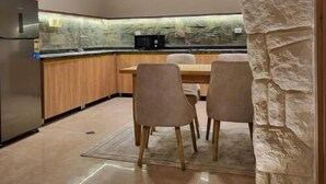Una cocina moderna con un arco de piedra, armarios de madera y un refrigerador de acero inoxidable.
