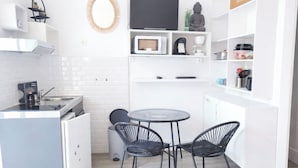 A compact kitchen with a microwave, coffee maker, and a small dining table with chairs. - Studio with a beautiful view of the sea of Anglet (Anglet)