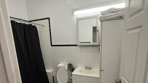 A bathroom with a toilet, sink, and mirror.