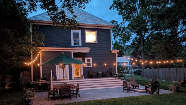 A house with a patio, outdoor seating, and string lights. - Spacious 5-bedroom House, Walking Distance to Williams (Williamstown)