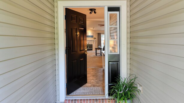 A house entrance with a dark wooden door, a small brick step, and a potted plant. - Water View Retreat | spacious 3br w/ lanai (Jacksonville)