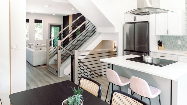 A modern kitchen with a central island, stainless steel appliances, and a staircase leading to another level. - Modern Private 3BR w/ ensuites & Garage in Charlotte mins from Airport & Uptown (Charlotte)