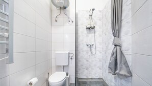 Un baño moderno con inodoro, ducha y perchero para toallas.