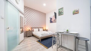 Un dormitorio moderno con cama, mesitas de noche, escritorio y una silla.
