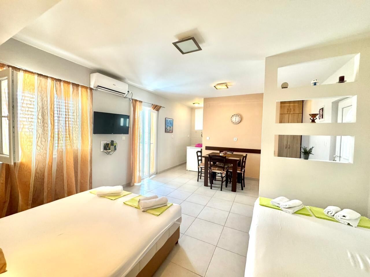 Habitación de hotel con dos camas, un comedor y un baño.