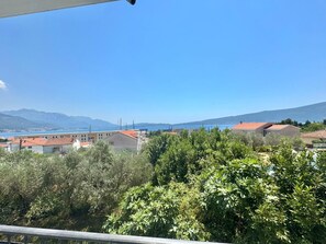 Une vue sur la côte, avec des bâtiments, des arbres et un ciel dégagé.