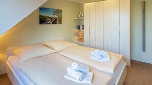 Un dormitorio moderno con una cama grande, un armario y un cuadro en la pared.