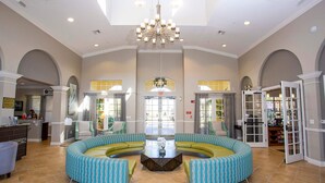 A spacious lobby with a central seating area, a chandelier, and a reception desk. - Disney Getaway! Townhouse with Private Pool. Book Now! #VC304 (Orlando)
