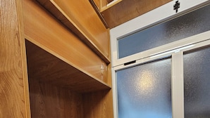A wooden closet with multiple shelves and a frosted glass window. - Real 43 *Good road (Neda)