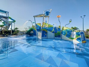 Un parque acuático con una piscina grande, toboganes de agua y una estructura de varios niveles.