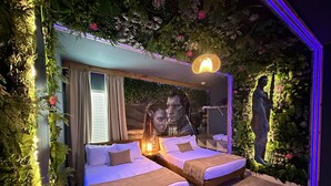 A room with two beds, a large mirror, and a wall with artificial greenery and a mural. - Last Minute Disney! Private Pool, Game Room & Themed Bedrooms. Book Now! #144011 (Orlando)